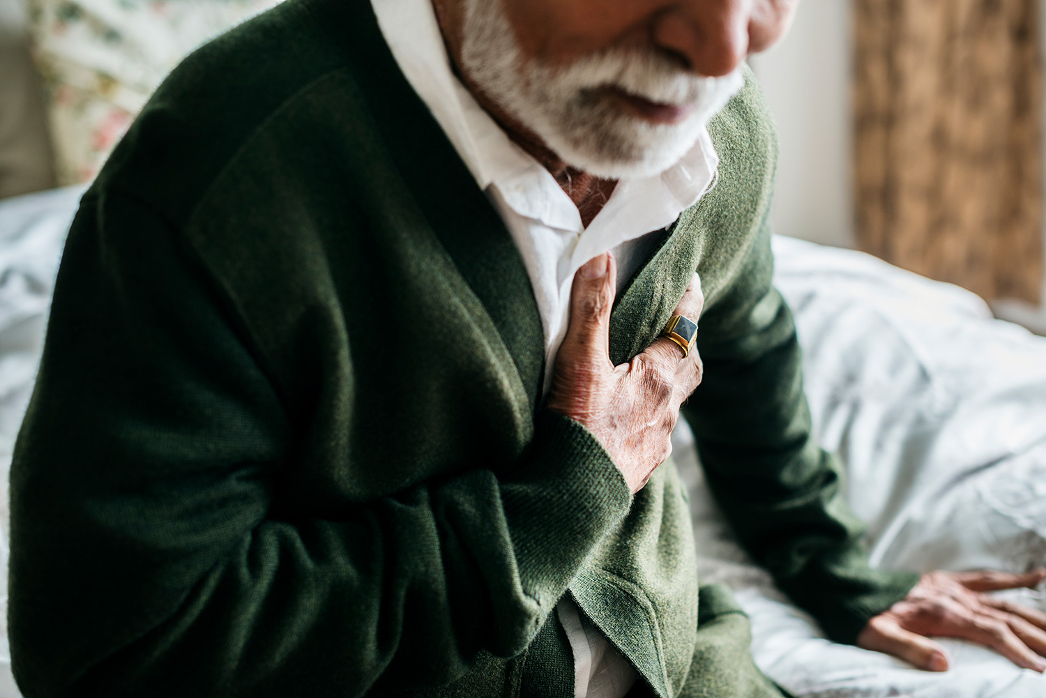 An older man clutching his chest in pain
