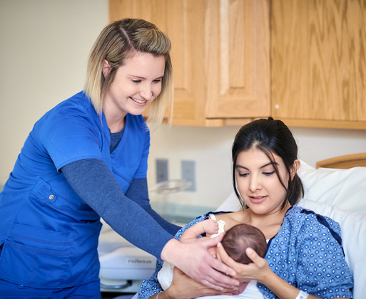 A nurse assisting a woman with her newborn child