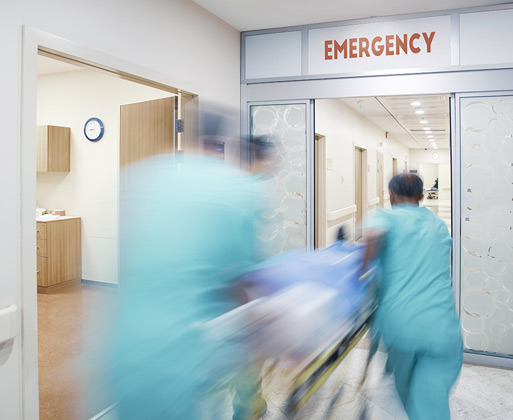 Emergency workers speeding through a hospital hallway
