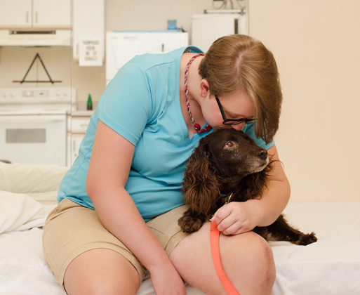 A woman snuggling with a dog