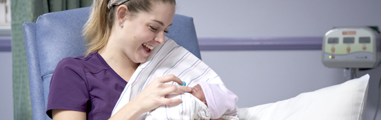 A woman cradling a newborn in her arms