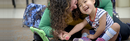 A woman playing a small child