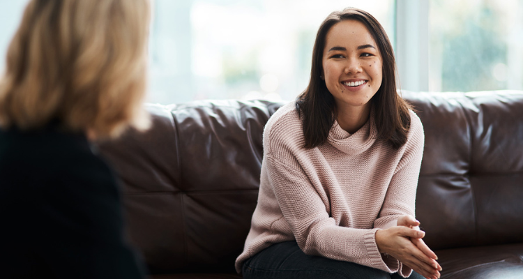 A woman speaking to a specialist on the couch