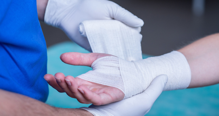 A physician bandaging up a hand