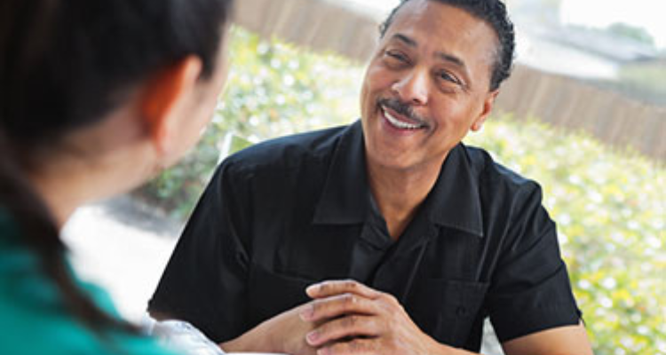 A middle-aged man speaking with a nurse