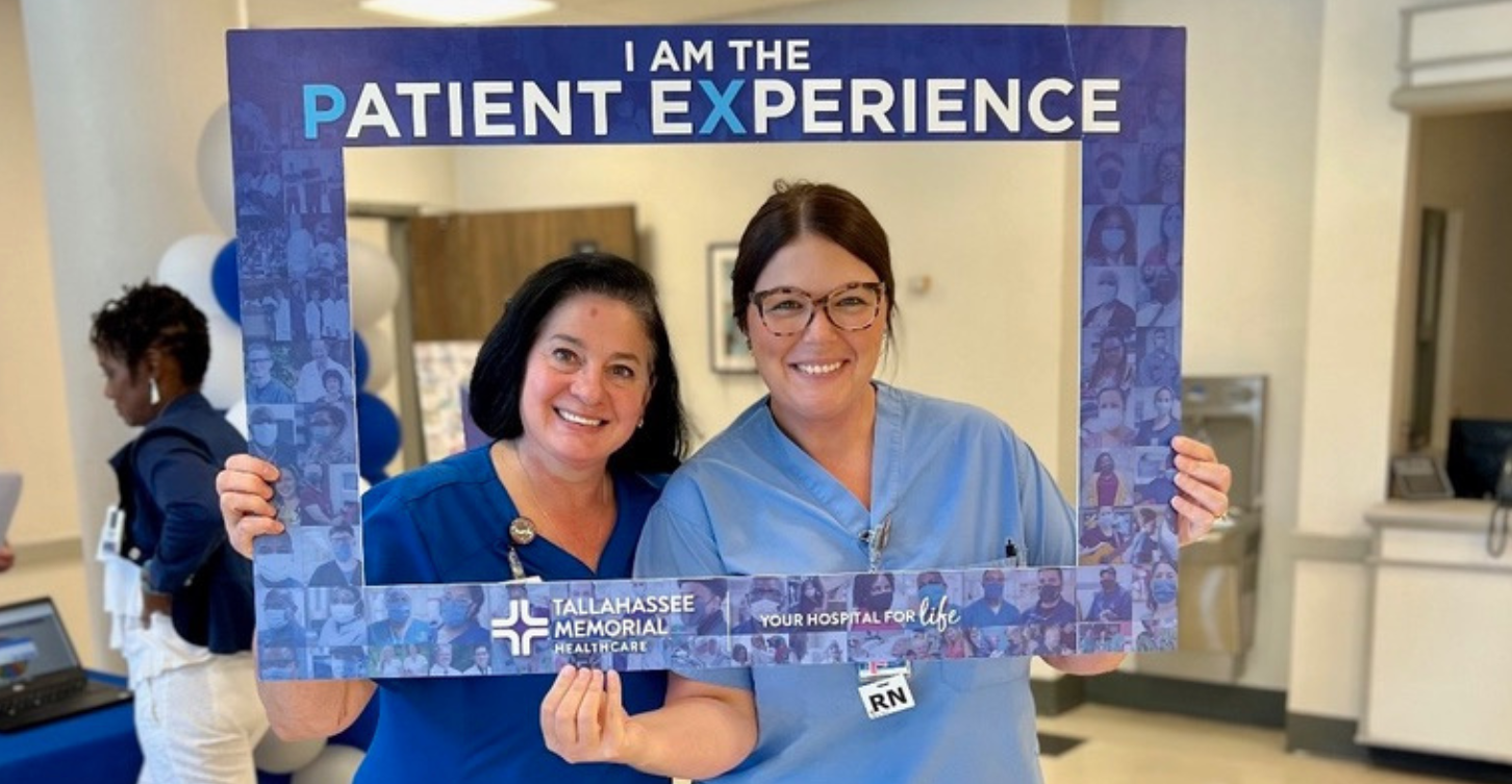 Angie and coworker holding photo prop