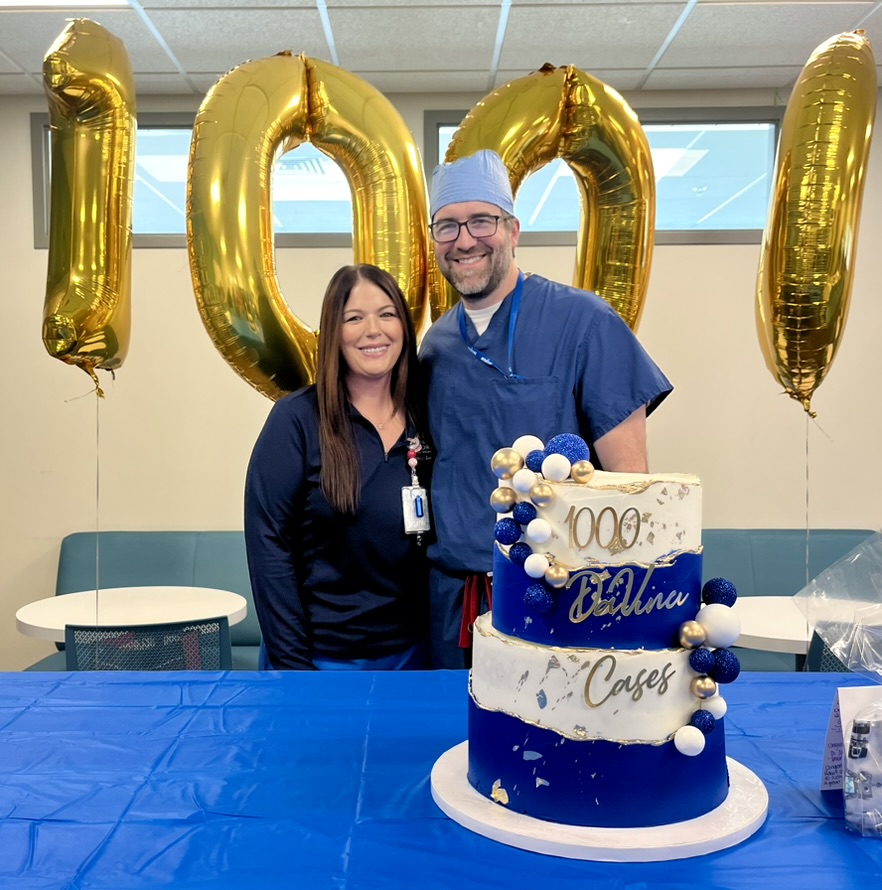 Angie and Dr. Jarrard pose for photo with cake