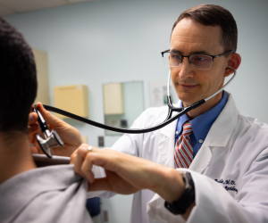 Doctor checking patients neck