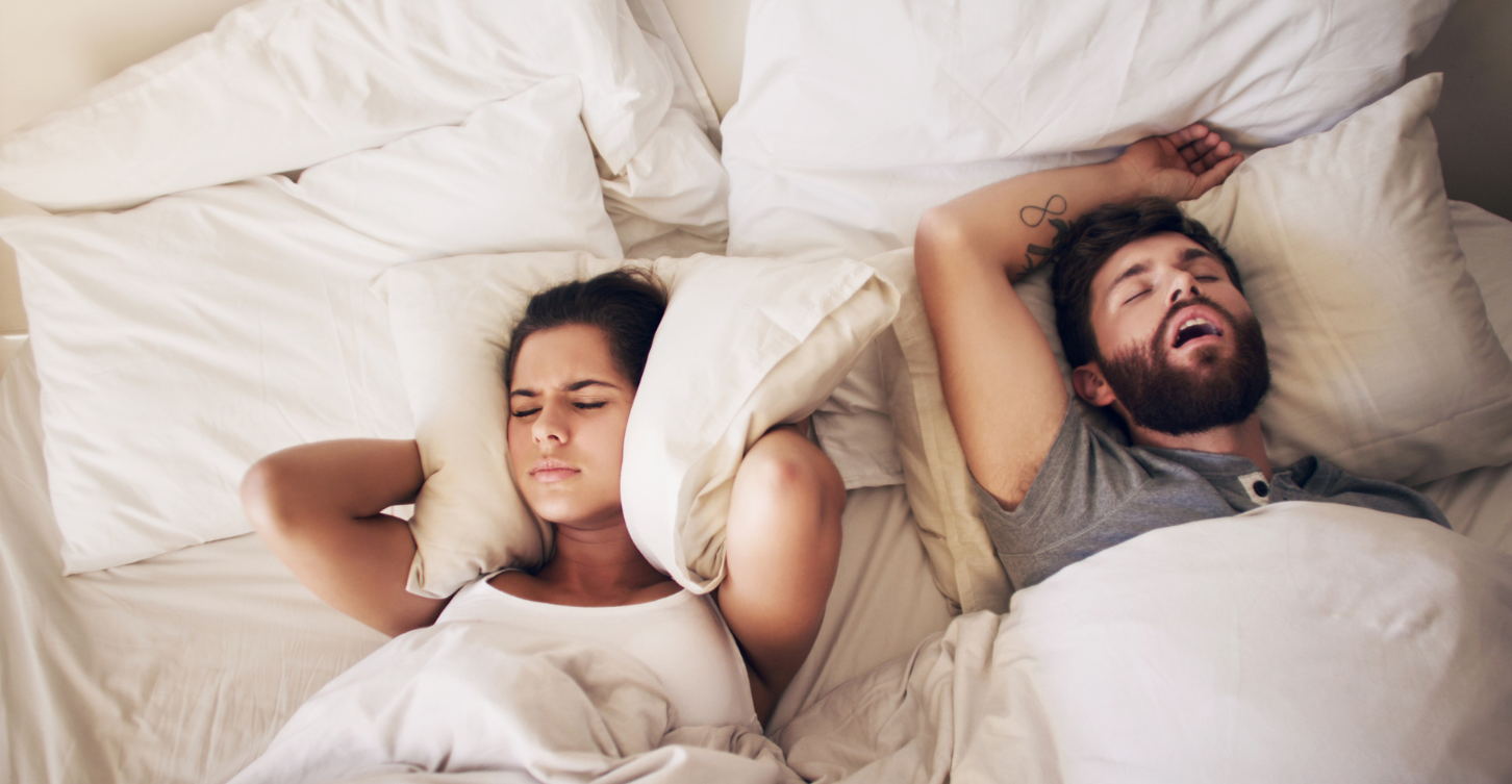 a couple in bed having difficulty sleeping