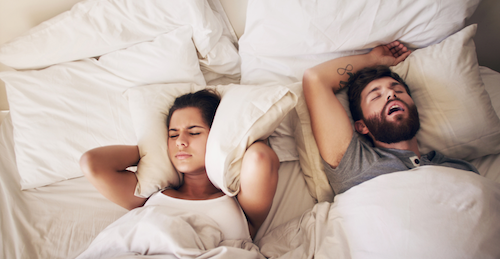 a couple in bed having difficulty sleeping