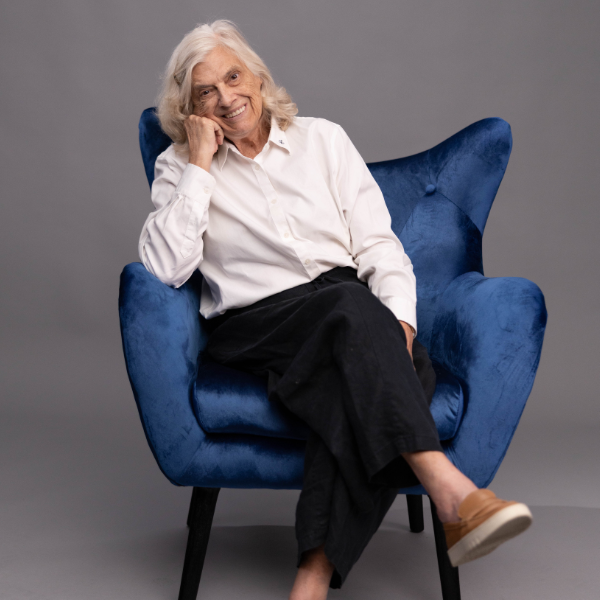 Camilla smiling while sitting in a blue chair