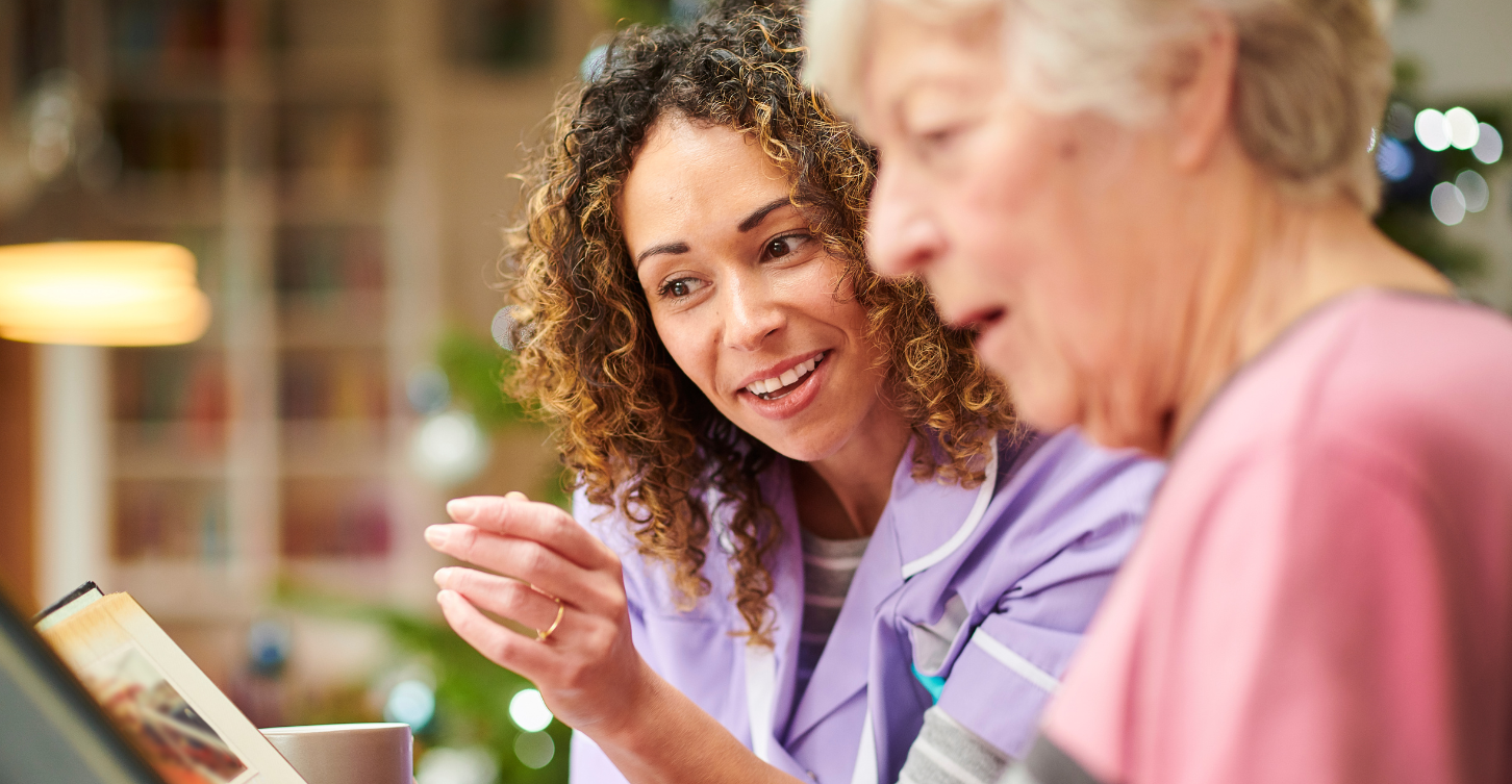 Woman showing older woman a book