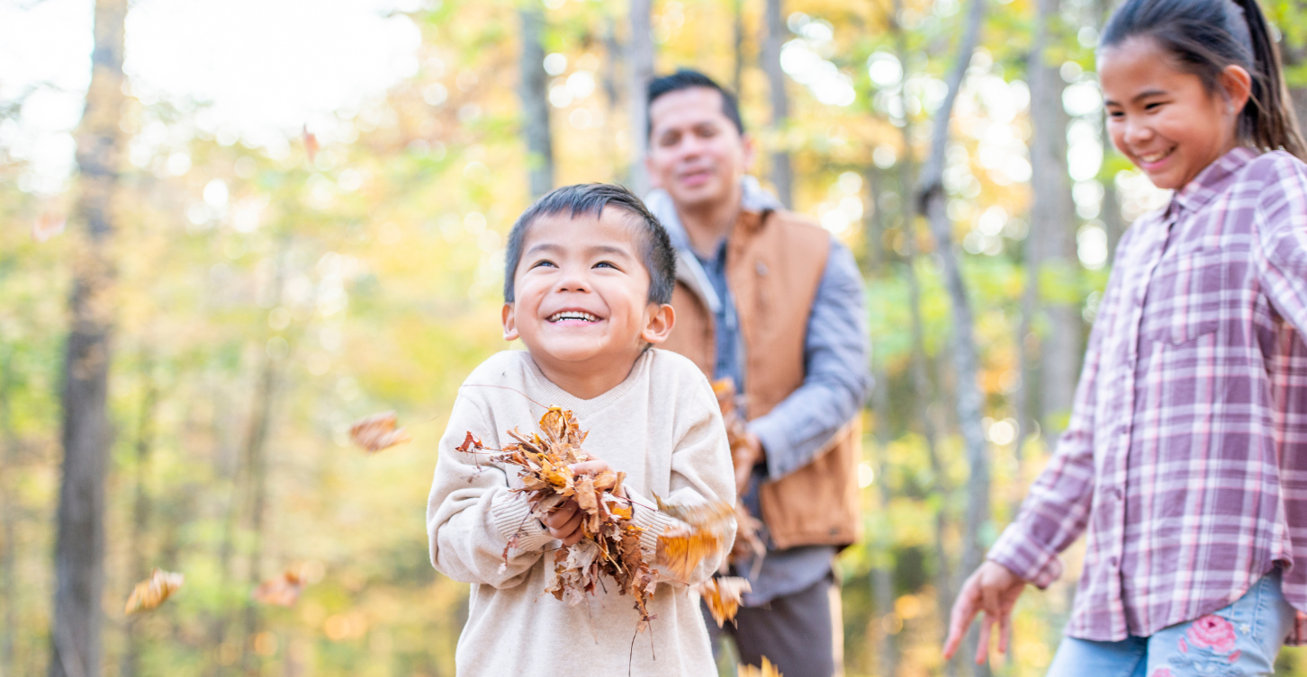 Family outside playing with leaves