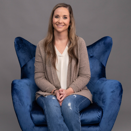 Kelly smiling in a blue chair