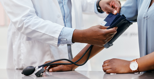 doctor placing blood pressure cuff on patient