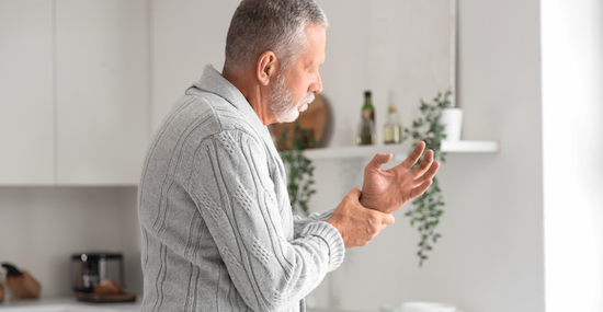 older man holding his hand