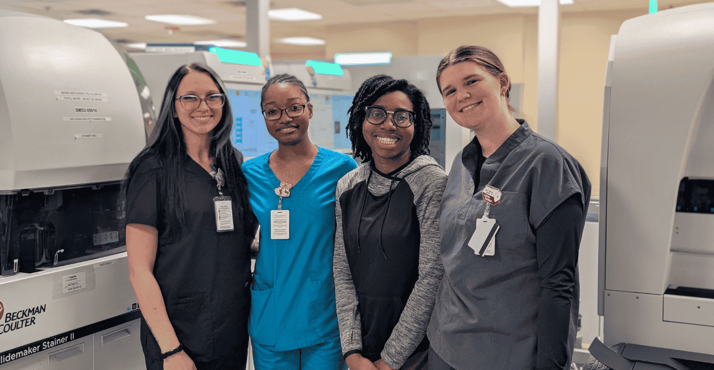 4 MLS students standing in a laboratory smiling
