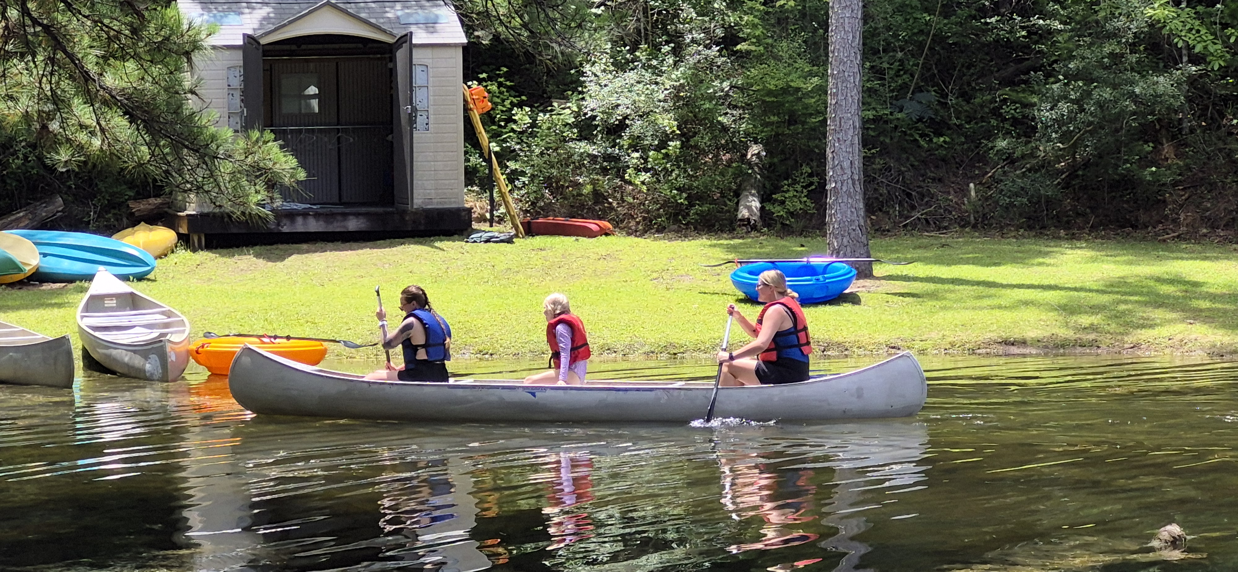 Three Florida Diabetes Camp participants paddling a canoe across a lake