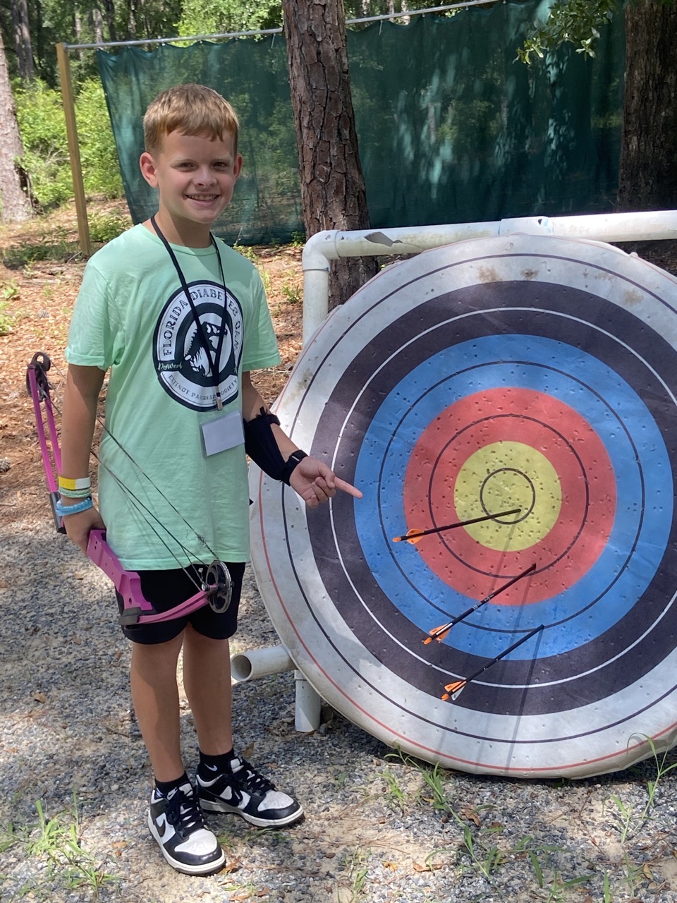 A camper shows off his arrows after practicing archery.