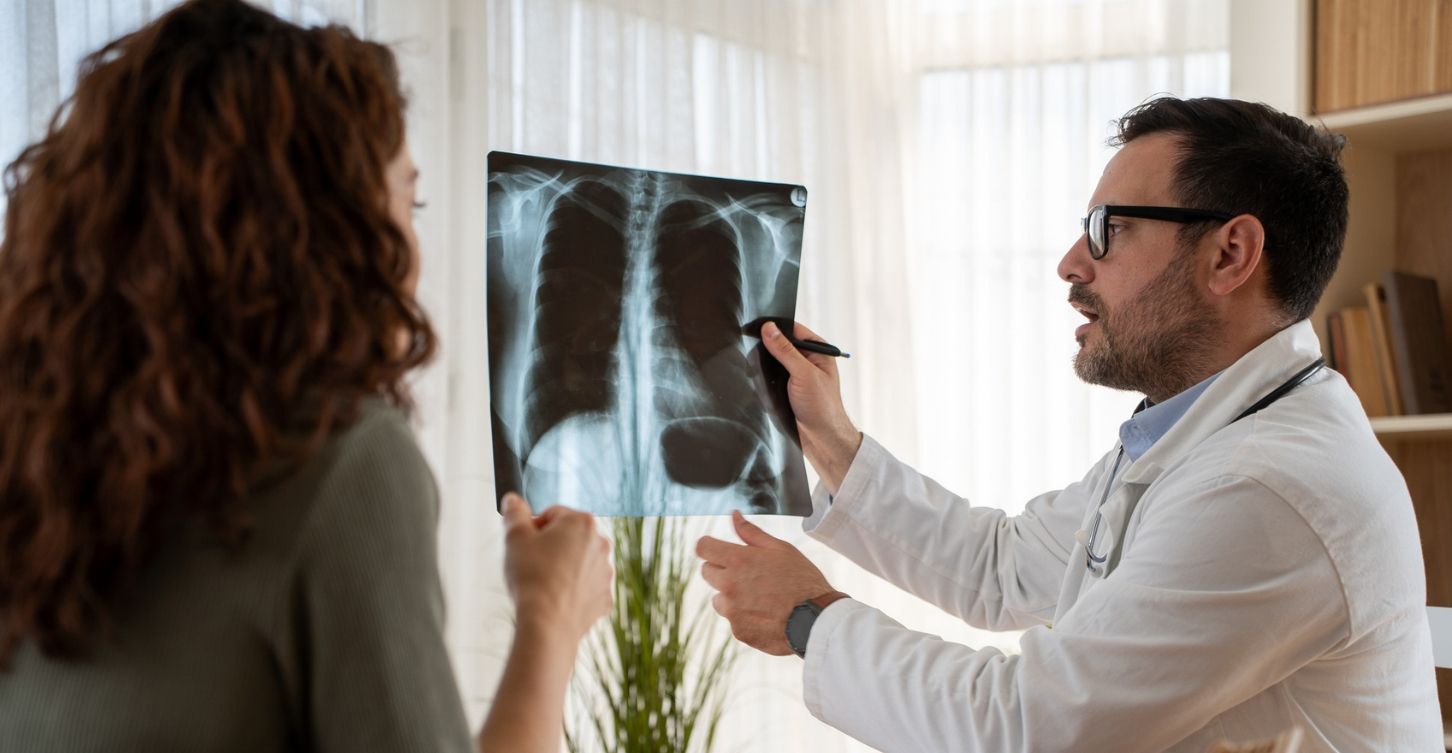 Who Needs to be Screened for Lung Cancer? doctor reviews a chest X-ray with a patient.