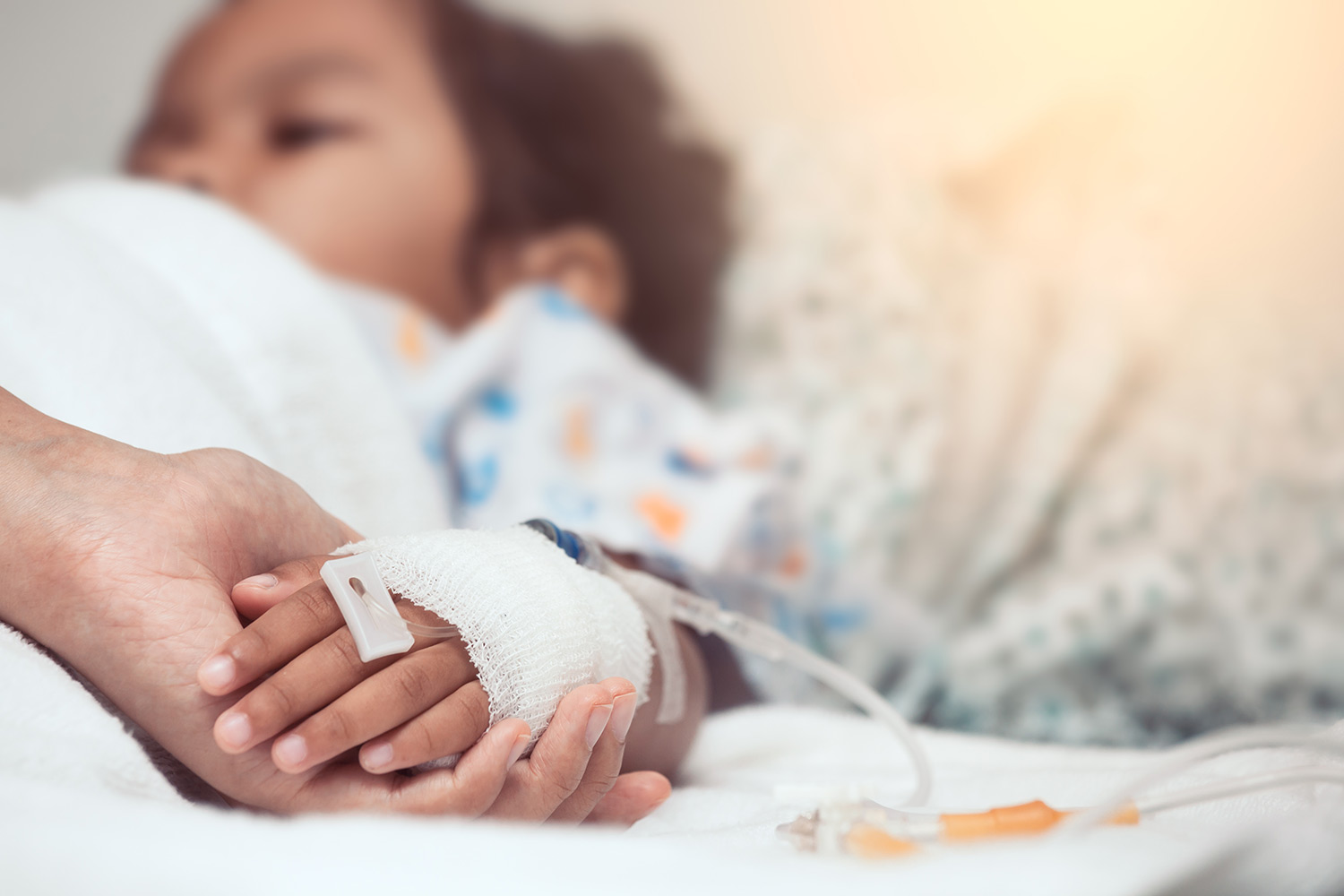 Someone holding a child patient's hand
