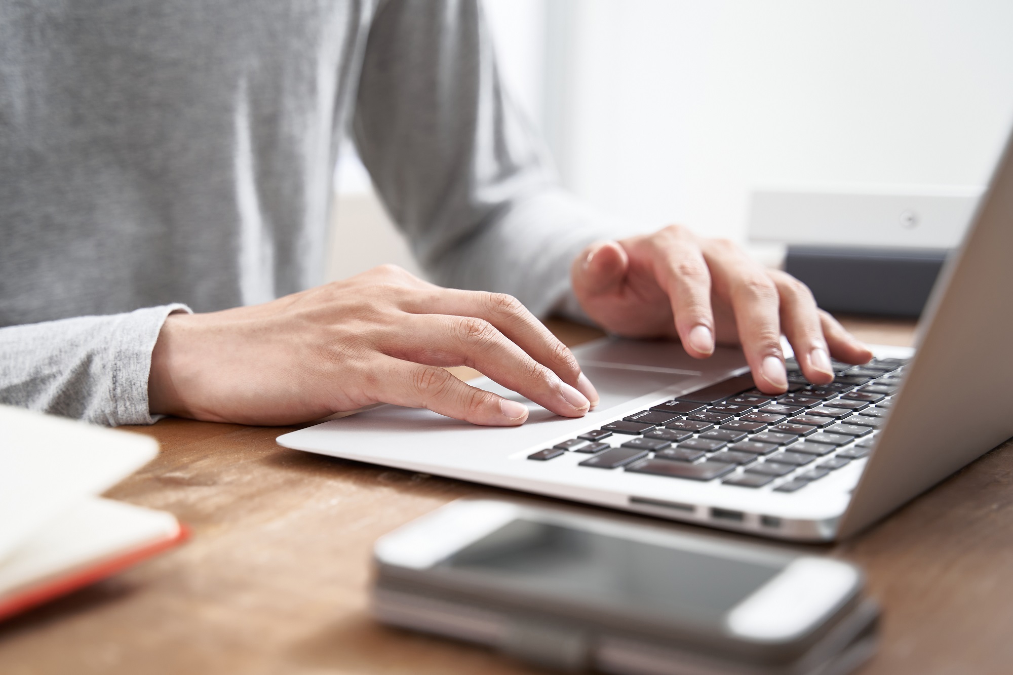 Hands typing at a laptop