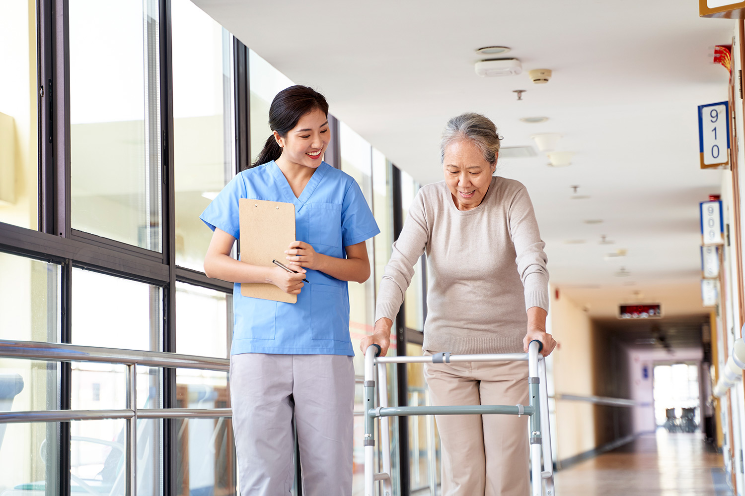 A nurse walking alongside a patient with a walker