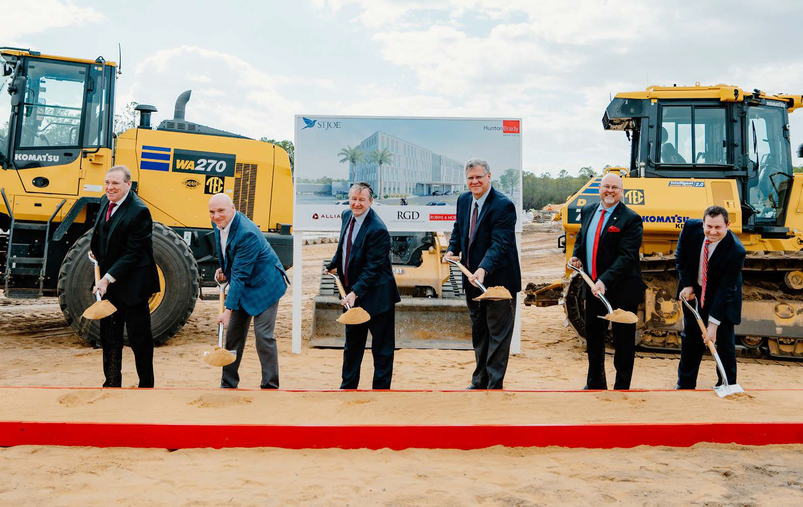 Men shoveling dirt at the groundbreaking of TMH's new campus