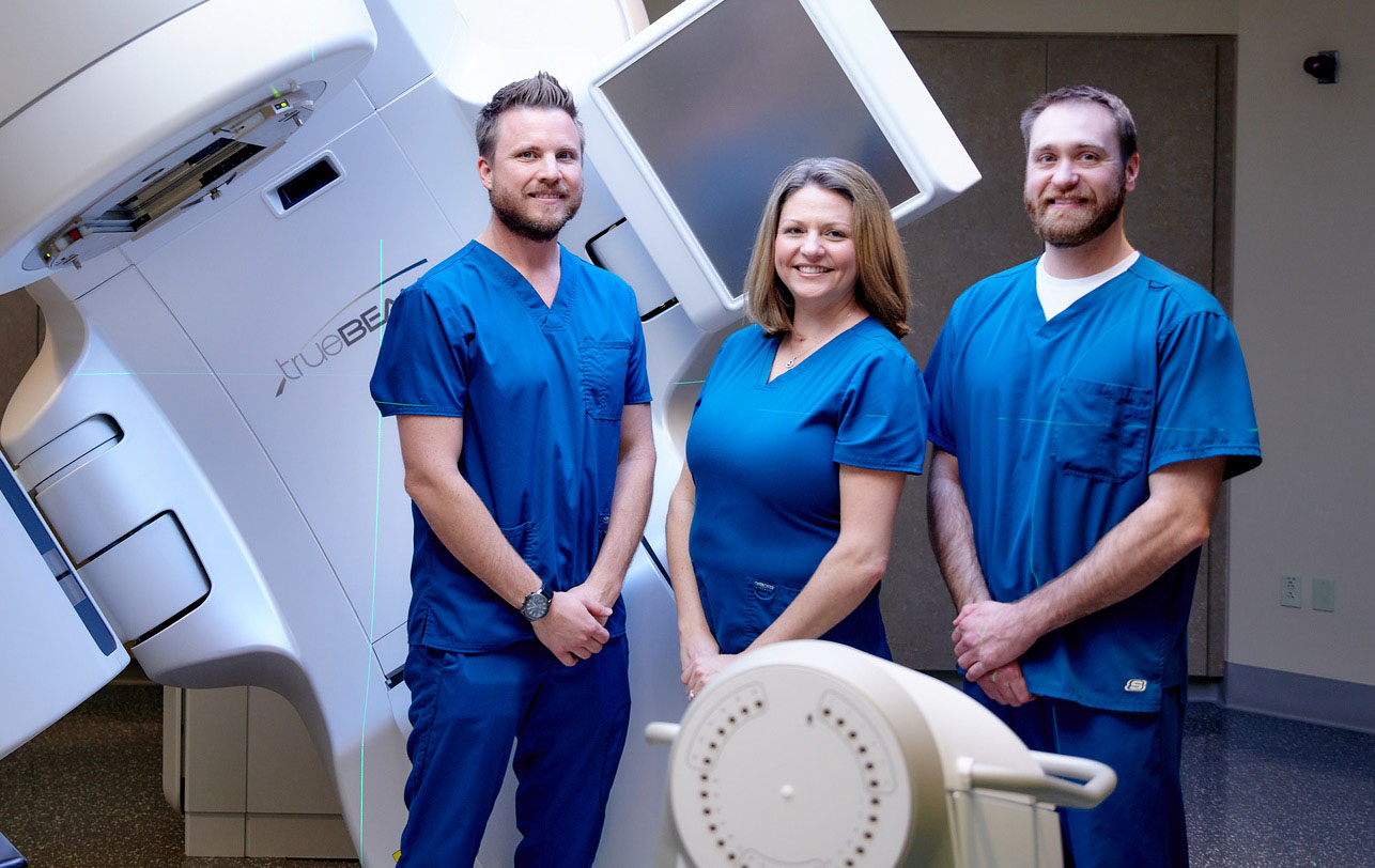 TMH team in front of Monarch radiotherapy equipment