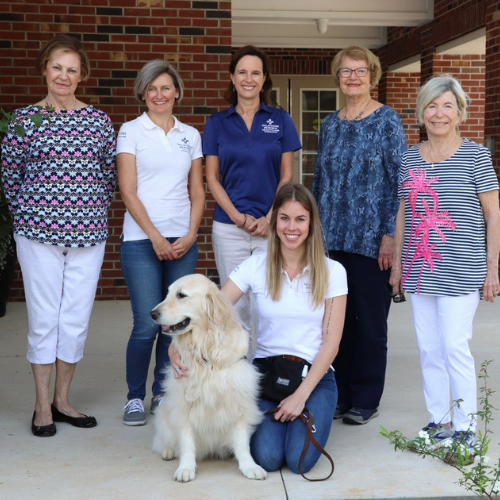 people standing with golden retriever