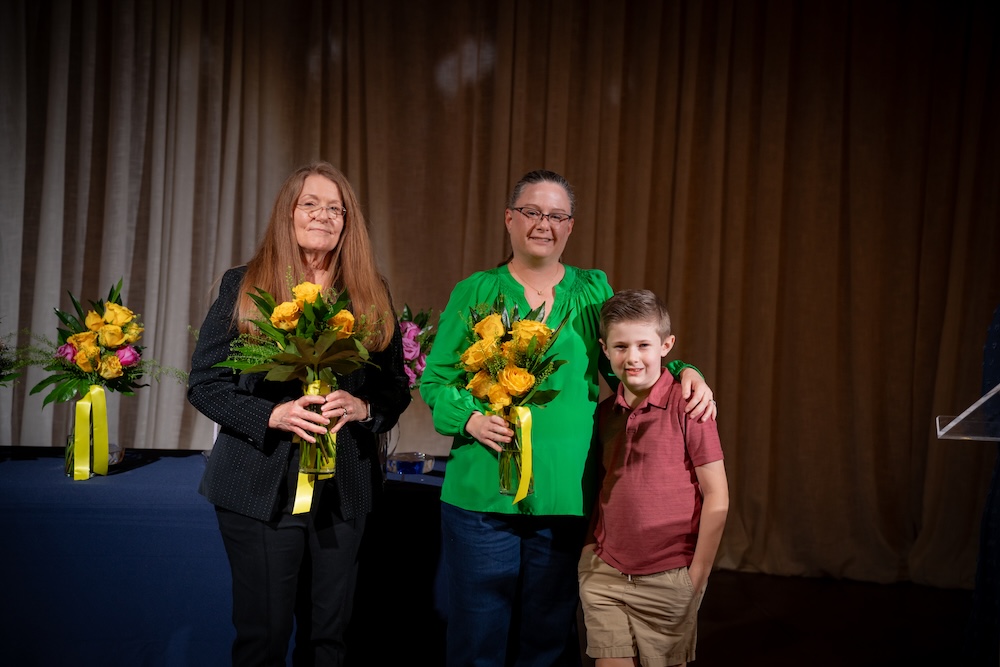 Two Daisy Award winners pose with flowers
